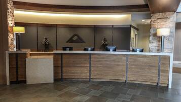 A reception area with a curved reception desk, stone accents, and a modern design.