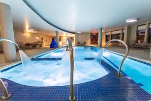Ett poolområde med flera bubbelpooler och solstolar.