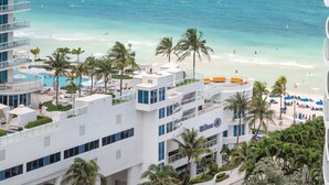 A hotel with multiple floors, a pool, and a beach view.
