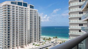 A high-rise hotel with multiple balconies overlooking a beach.