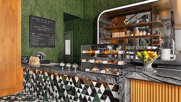 En kaffebar med et verdenskort, en menutavle og et udvalg af kager og kaffe.