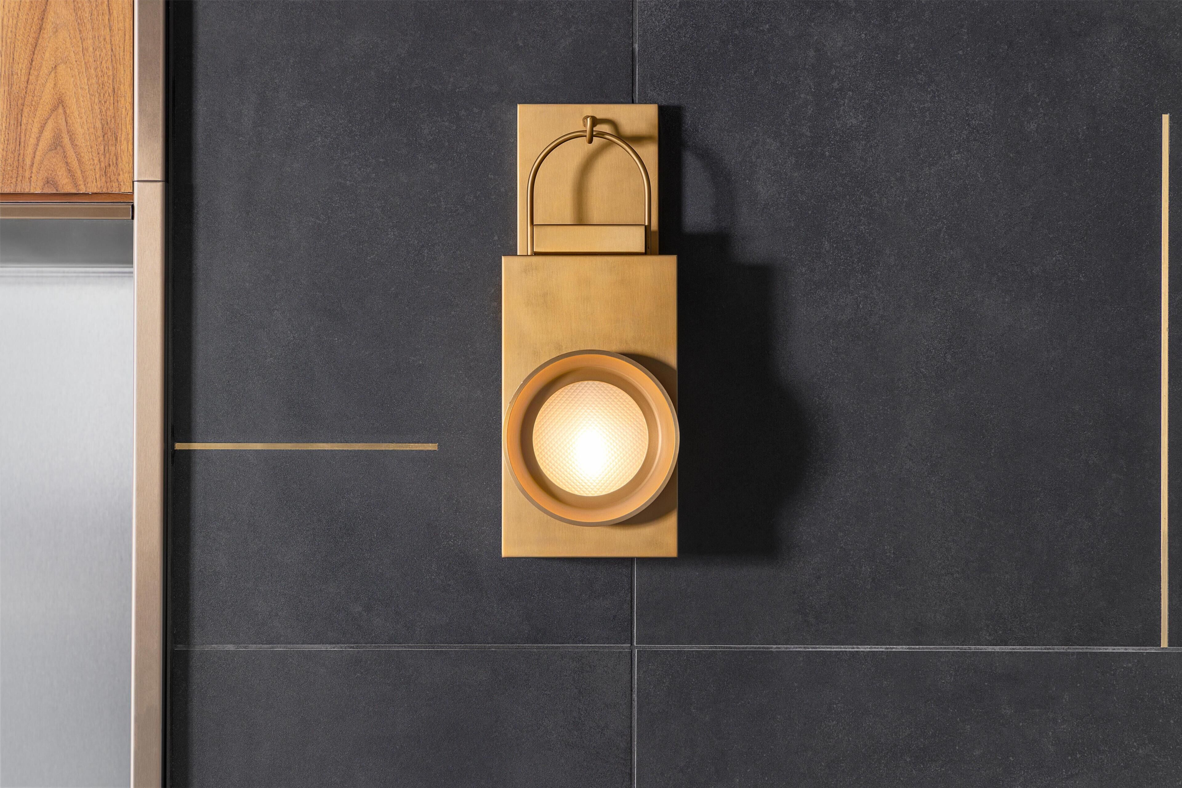 A modern kitchen with dark tiles, a wooden cabinet, and a light fixture.