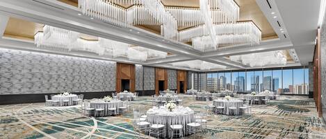 A spacious conference room with multiple tables, a patterned carpet, and a cityscape view through large windows.