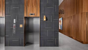 An elevator with a modern design, a wall-mounted light, and a directional sign.