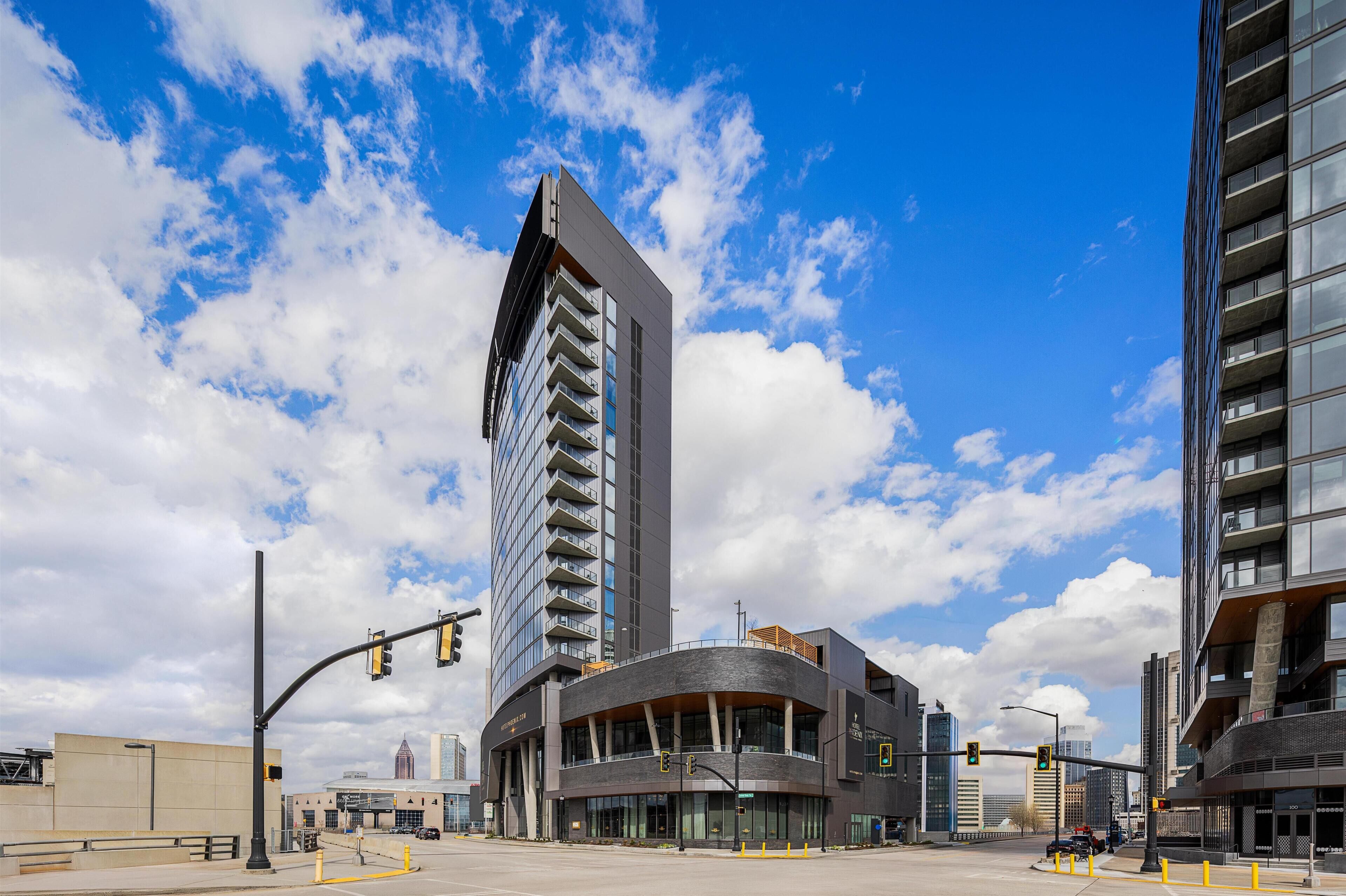 A modern building with a curved facade, large windows, and a prominent vertical structure.