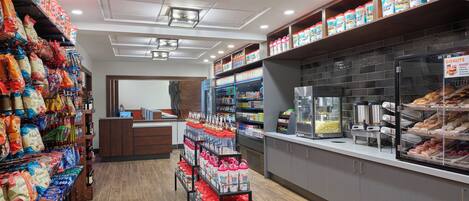 A bakery with shelves of baked goods and a popcorn machine.