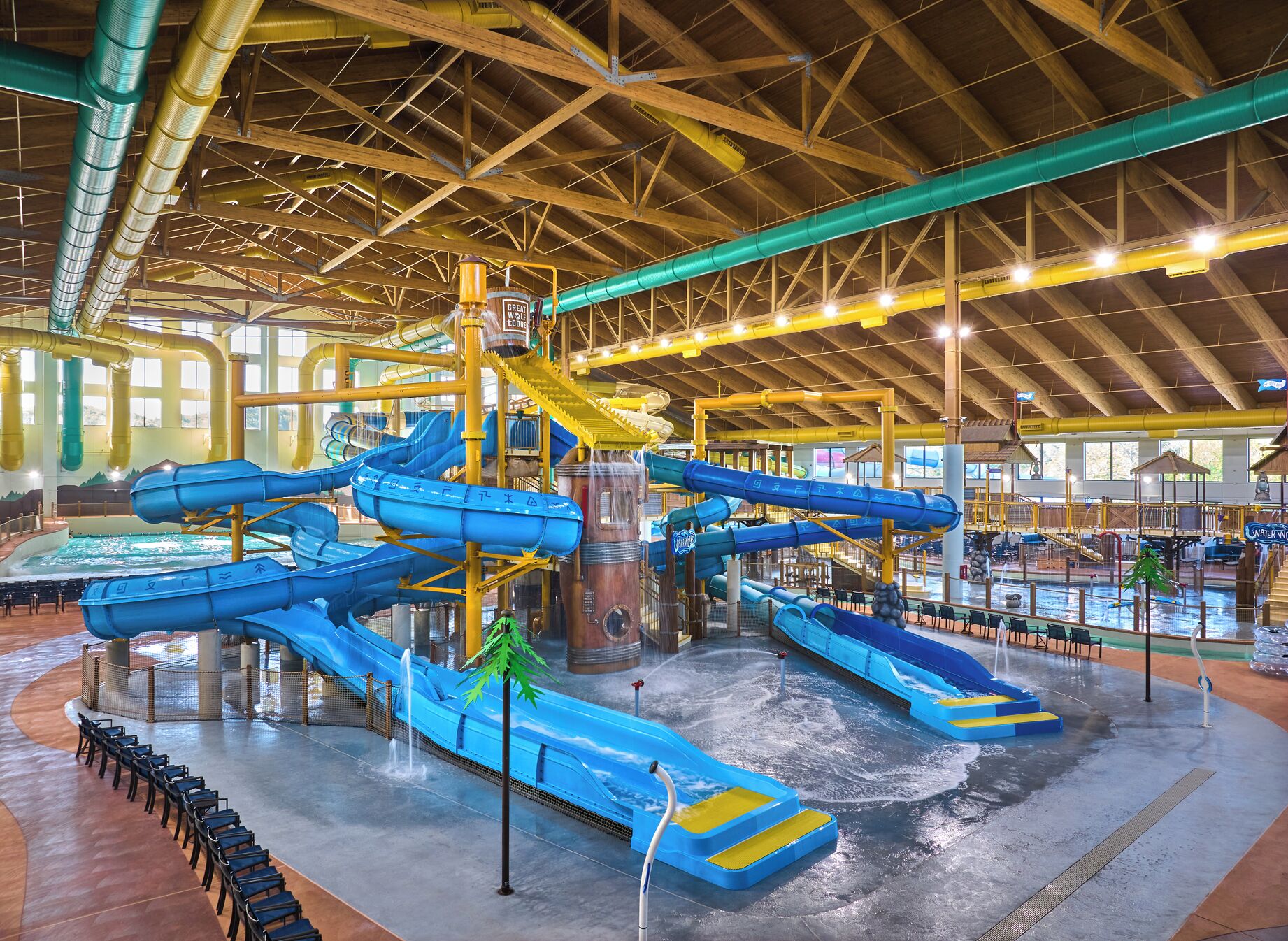 Parque acuático interior con múltiples toboganes y piscinas.