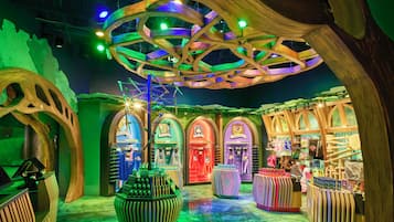 A brightly lit indoor space with wooden structures and arches, featuring various displays and merchandise.