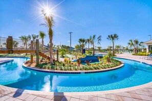 A pool area with palm trees, a covered seating area, and a clear blue sky. - Private Disney Oasis With Pool Hot Tub Ps5 and Modern Amenities (Kissimmee)