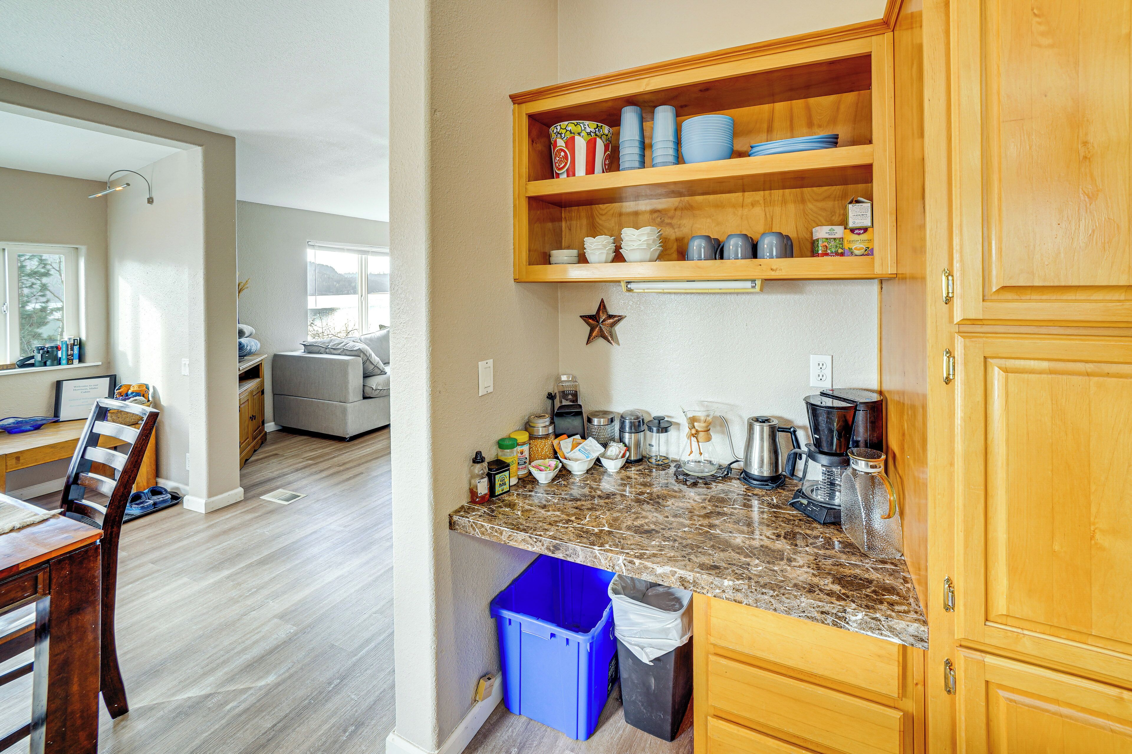 A kitchen with wooden cabinets, a granite countertop, and various kitchen appliances.