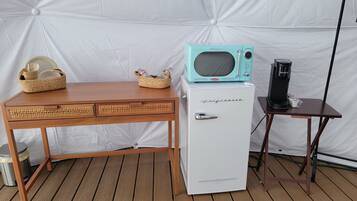 Una kitchenette compacta con un refrigerador blanco, un microondas de estilo retro y una cafetera sobre una mesita.