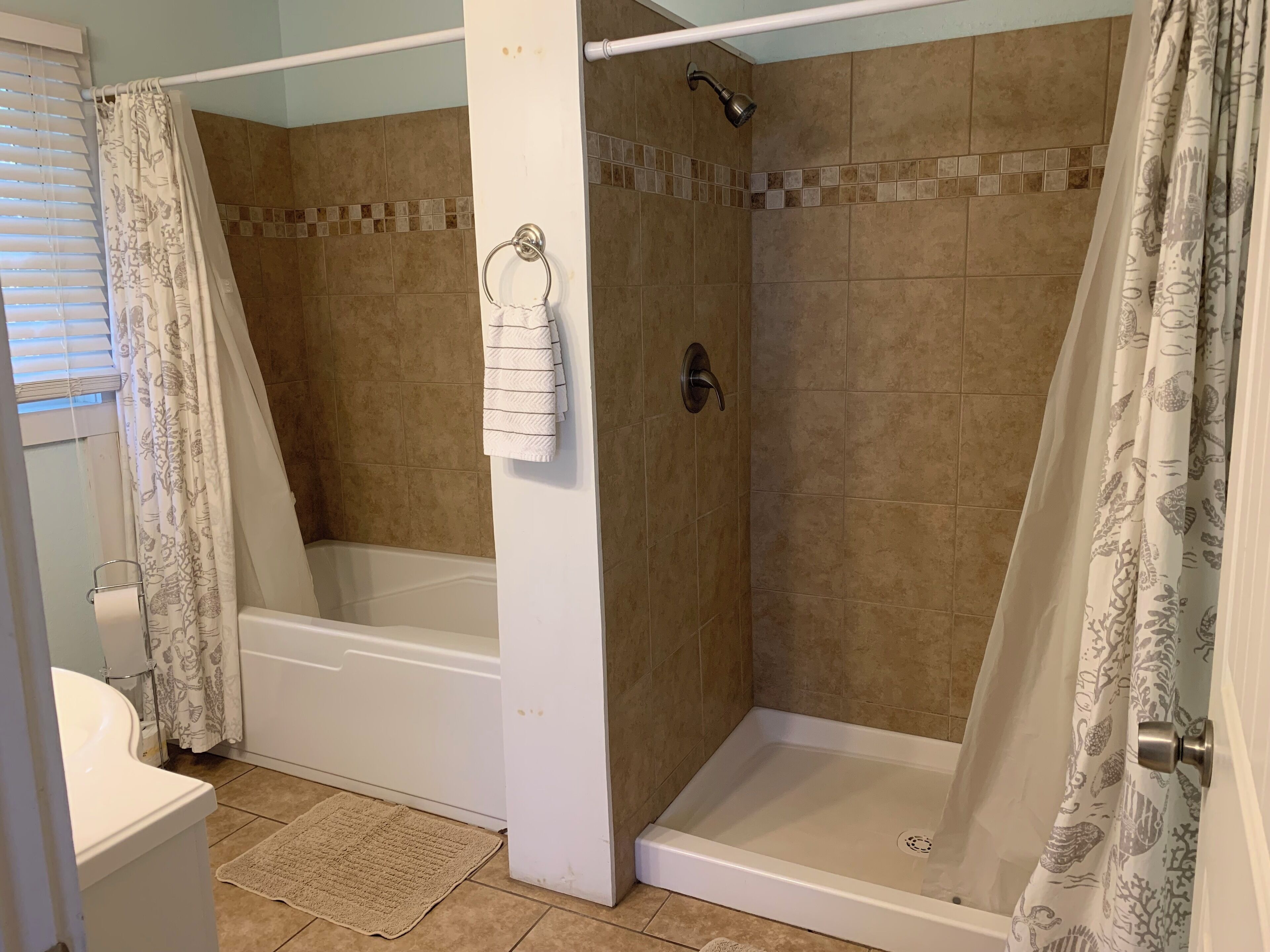 A bathroom with a shower, toilet, and bathtub.