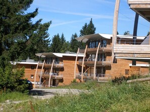 A modern building with multiple balconies and a wooden facade. - 70m from ski slopes, fitness, swimming pool, sauna, terrace, balcony, parking, tv, 32-42m² (Chamrousse)
