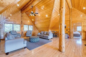 A spacious loft-style room with a high ceiling, wooden beams, a ceiling fan, and a bed in the corner. - Sleeps 21 Luxury Cabin w/ Panoramic View, Hot Tub, Game Room Pinnacle Chalet (Gatlinburg)