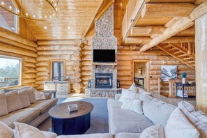 A log cabin interior with a stone fireplace, wooden walls, and a cozy seating area. - Sleeps 21 Luxury Cabin w/ Panoramic View, Hot Tub, Game Room Pinnacle Chalet (Gatlinburg)