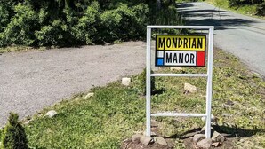 Un panneau indiquant « Mondrian Manor » sur une route de campagne.