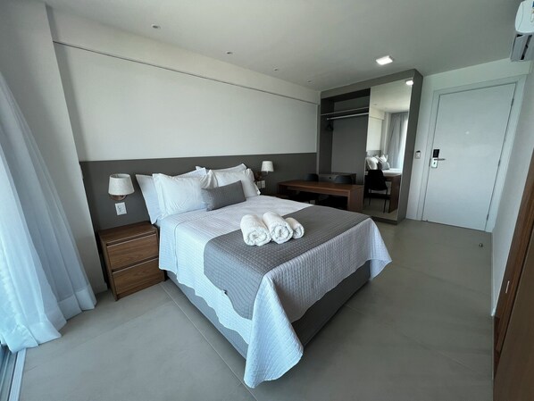 A modern hotel room with a large bed, bedside tables, a desk, and a wardrobe. - RN STUDIO - APTO 1010 (Maceio)