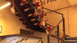 Egy márványhatású mintázatú lépcső, egy „5 PARK” felirattal ellátott fa fal, és karácsonyi díszek.