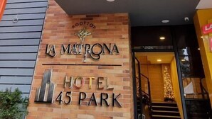 A La Matrona Hotel 45 Park épületének külső megjelenése: téglafalas homlokzat, modern bejárat és zöld növények a balkonokon.