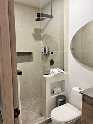 A modern bathroom with a glass-enclosed shower, a toilet, a sink with a mirror, and a towel rack. - HOTEL 45 PARK (Sabaneta)