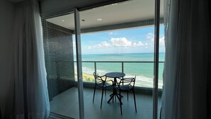 Ein Balkon mit Blick auf den Ozean, einem Tisch und Stühlen.