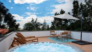 A rooftop terrace with a hot tub, wooden lounge chairs, a table, and an umbrella. - Amaro Oasis by LovelyStay (Funchal)