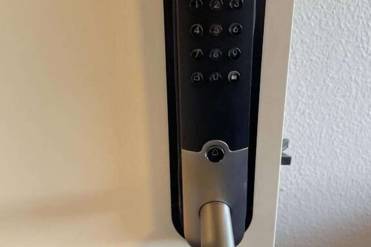 A modern door with a keyless entry keypad and a lever handle.