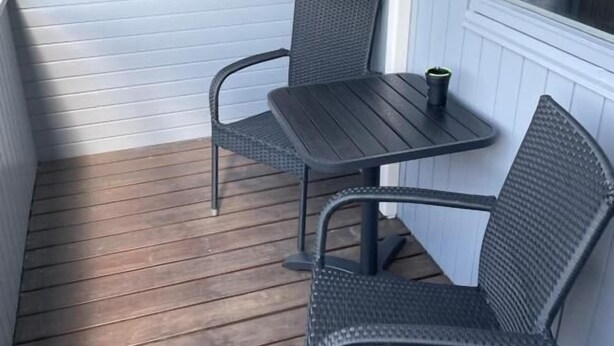 A small outdoor patio with a table and two chairs. - Marielyst Guesthouse (Vaeggerlose)