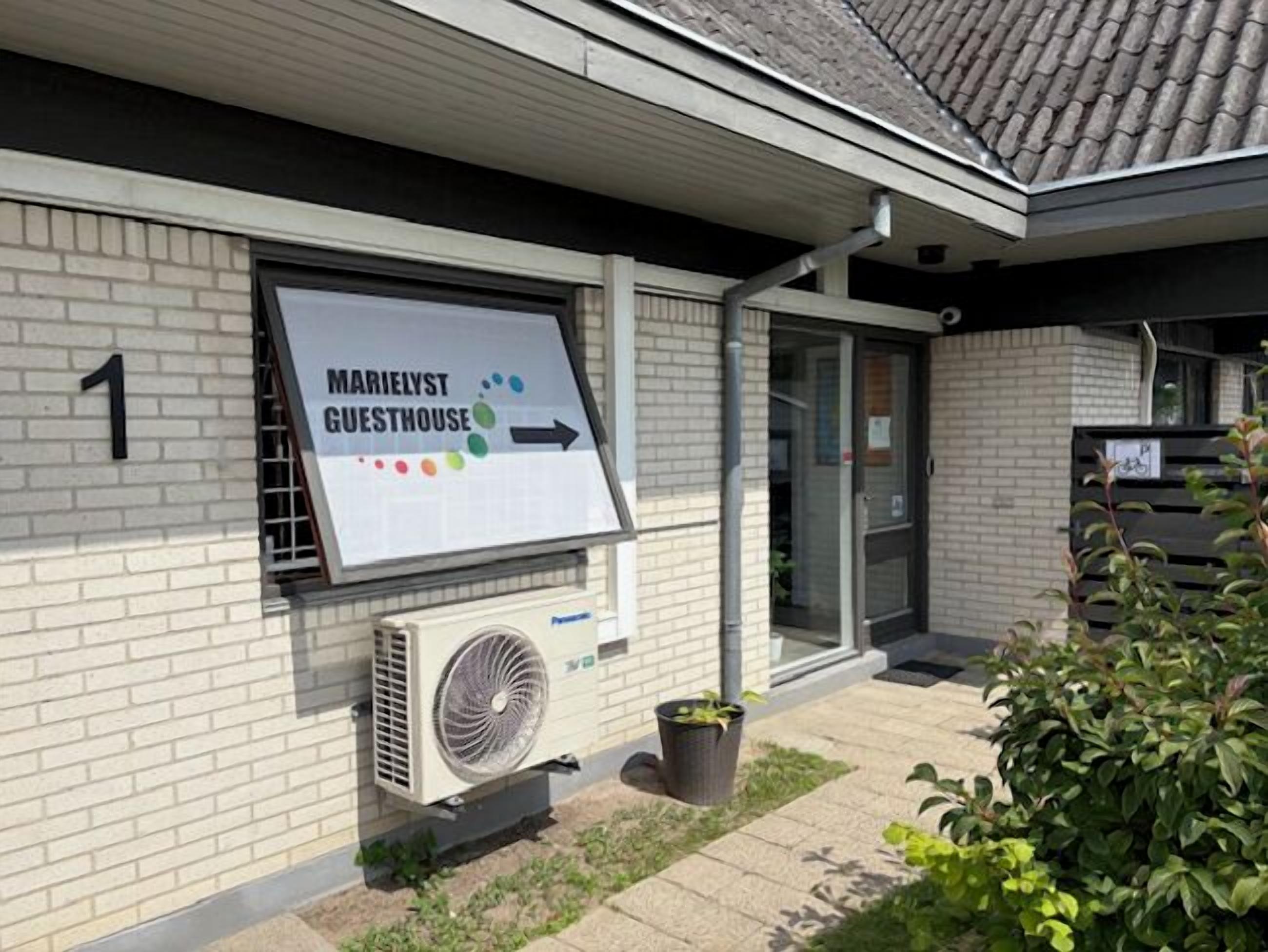 A building with a sign for 'Marielyst Guesthouse' and a number '1' on the wall.