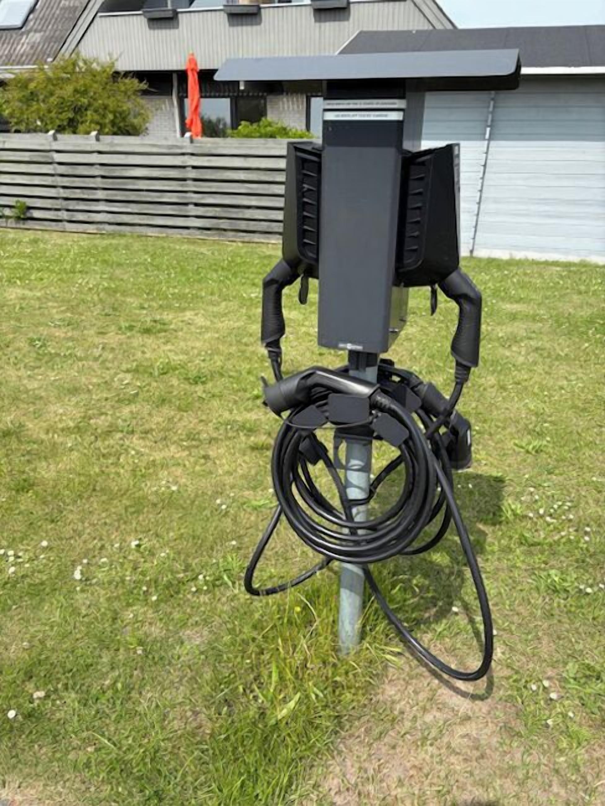 An outdoor electrical box with cables on a grassy area.