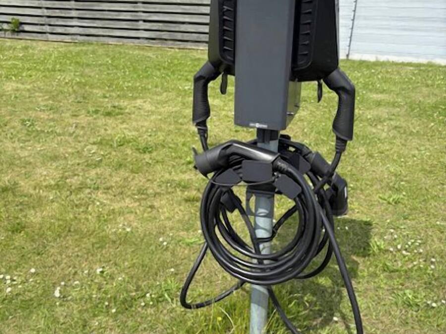 An outdoor electrical box with cables on a grassy area.