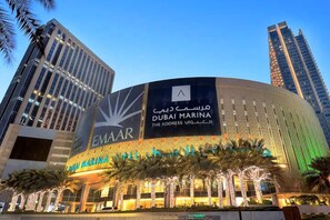 A modern building with a large sign for 'Dubai Marina' and 'EMAAR.'
