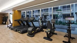 Een sportschool met loopbanden, elliptische trainers en hometrainers.