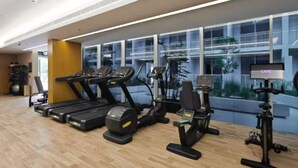 A gym with treadmills, elliptical machines, and stationary bikes.