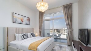 Een moderne hotelkamer met een groot bed, een televisie, een balkon met zitplaatsen buiten, en uitzicht over de stad.