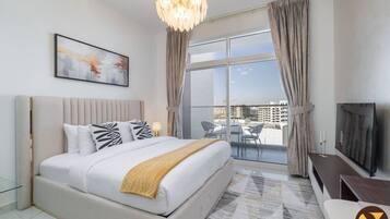 Une chambre d’hôtel moderne dotée d’un grand lit, d’une télévision, d’un balcon avec coin salon extérieur et offrant une vue sur la ville.