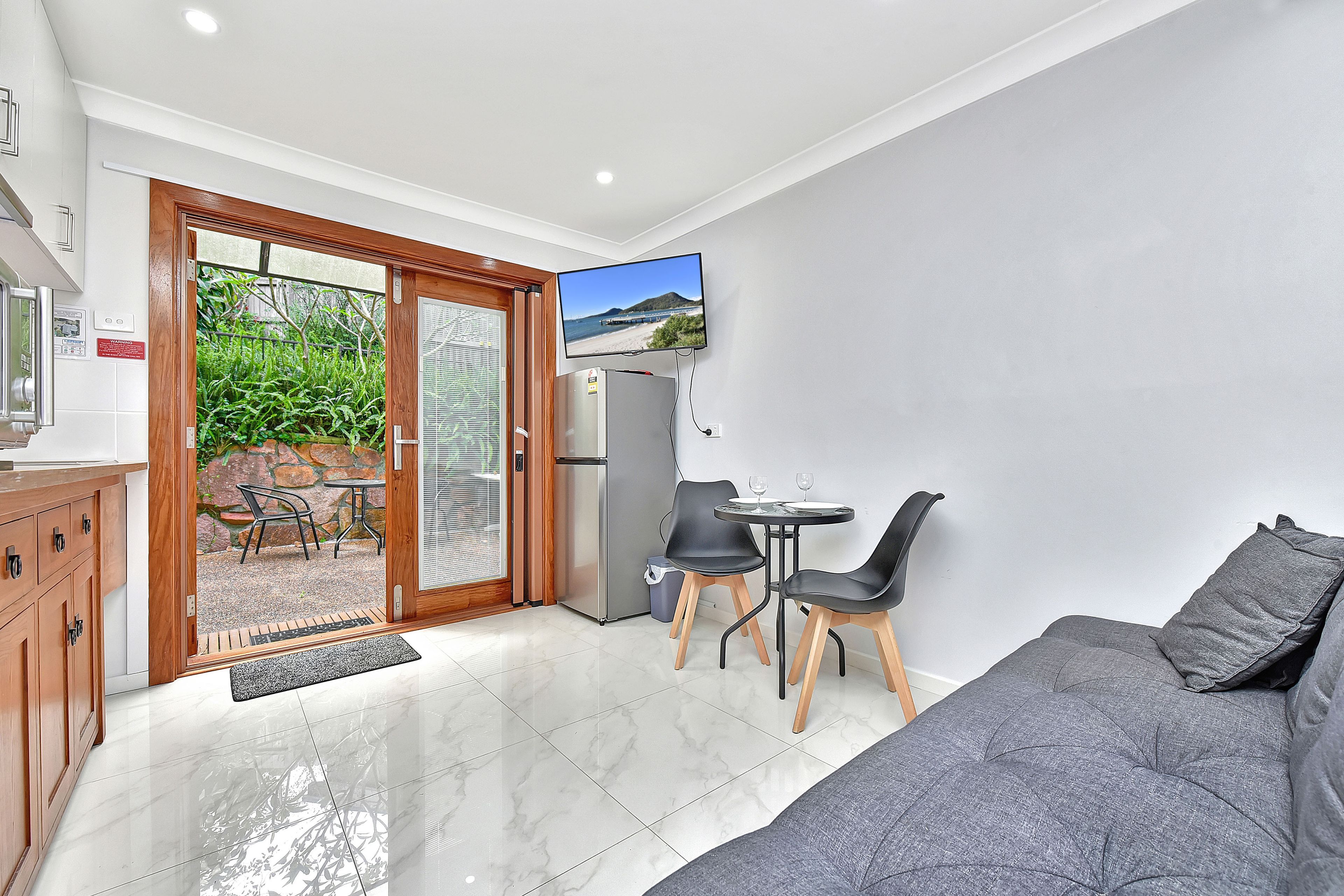 A compact living space with a kitchenette, a dining area, and a seating area with a sofa and chairs.
