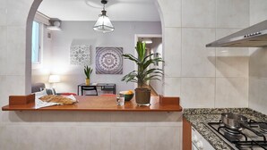 Een keuken met een aanrecht, een fornuis en een hangende lamp.