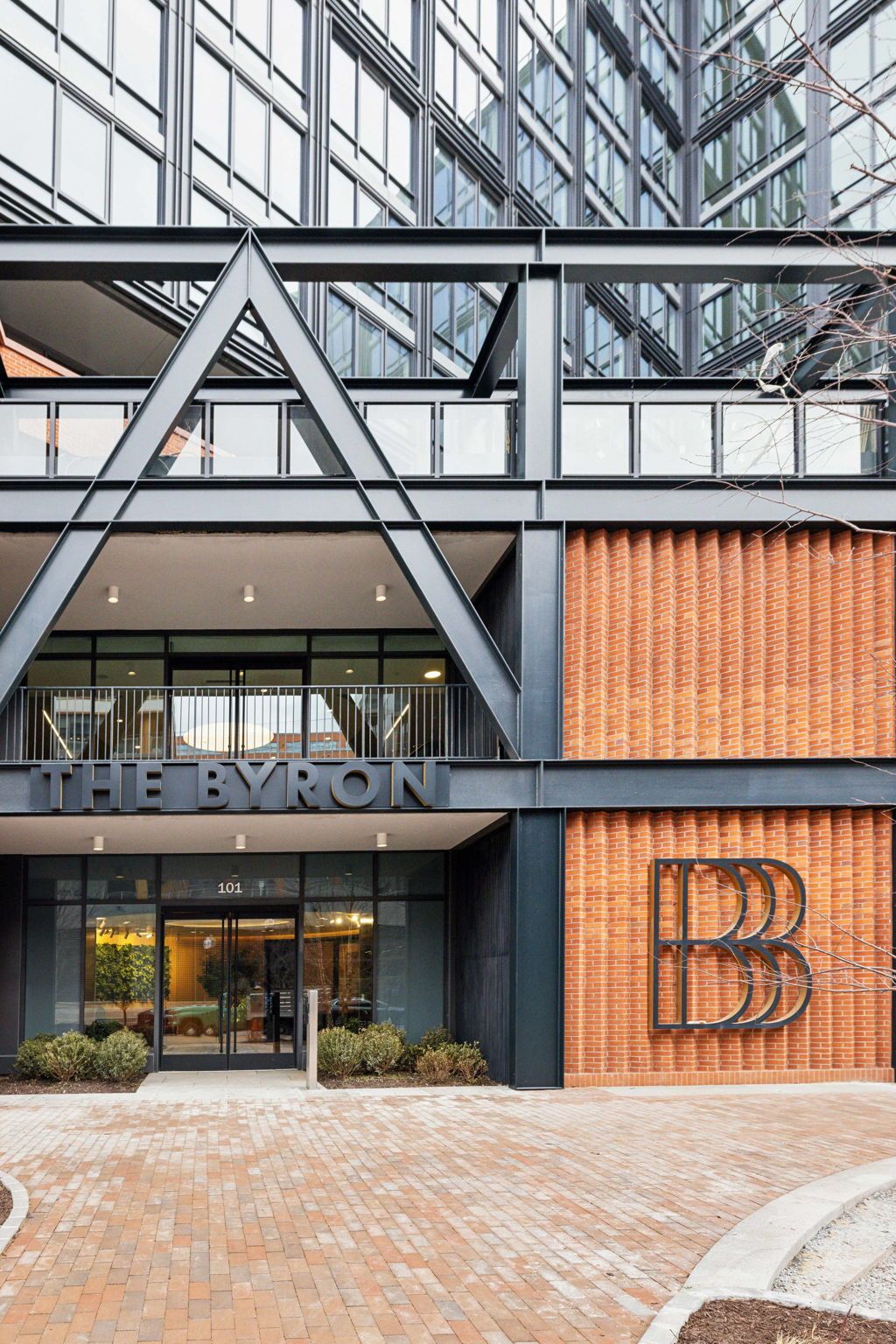 A modern building with a prominent 'BYRON' sign, featuring a glass entrance and a brick facade.