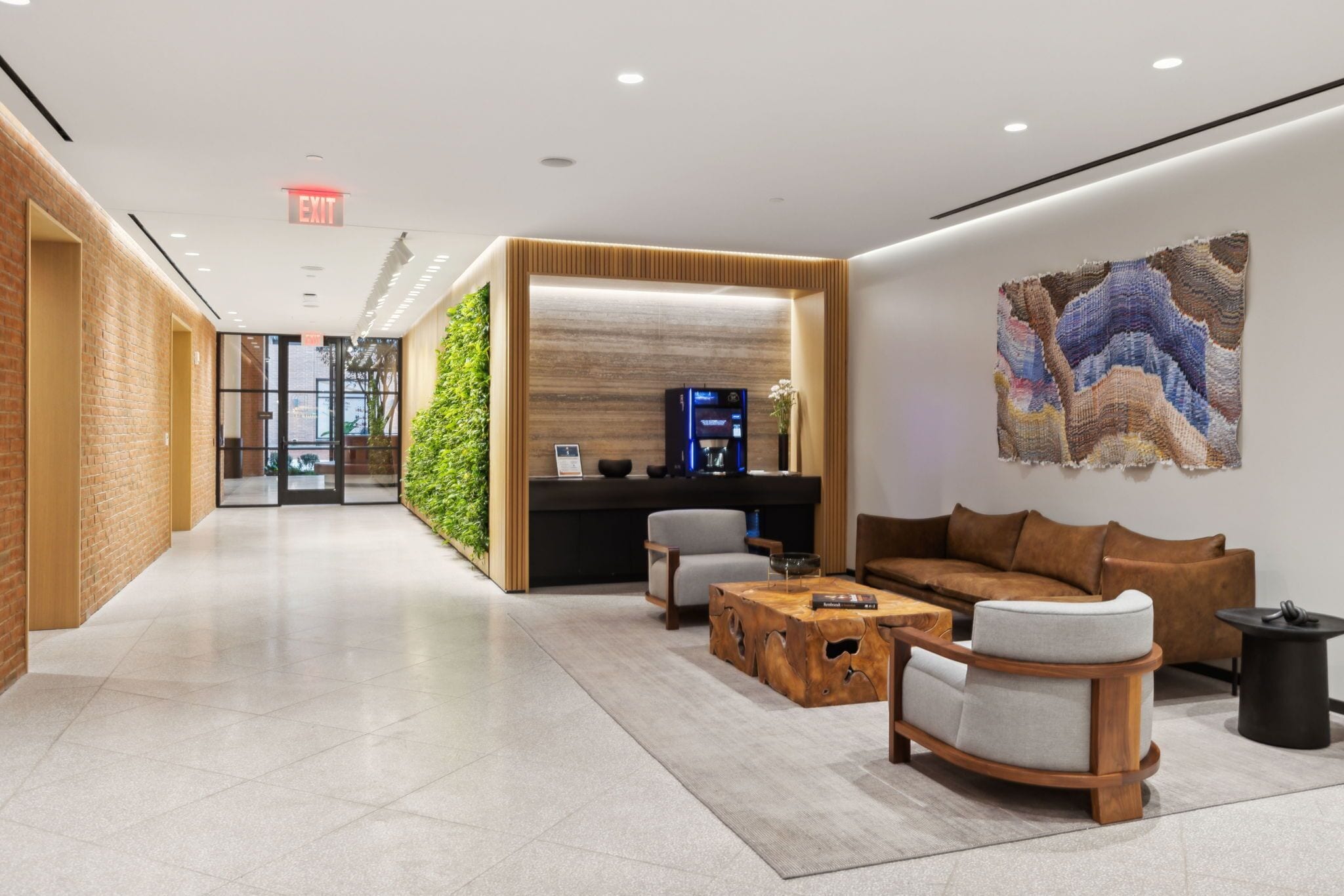 A modern lobby with a reception desk, seating area, and a large abstract painting.