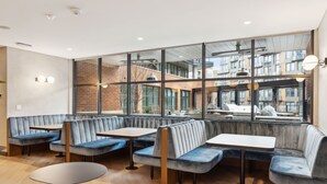 A modern interior with seating arrangements and large windows. - Placemakr Buzzard Point (Washington)