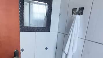 A small bathroom with a white sink, a mirror, and a towel rack.