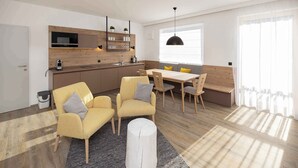 Una cocina moderna con electrodomésticos integrados, un comedor con muebles de madera y un amplio ventanal que proporciona luz natural.