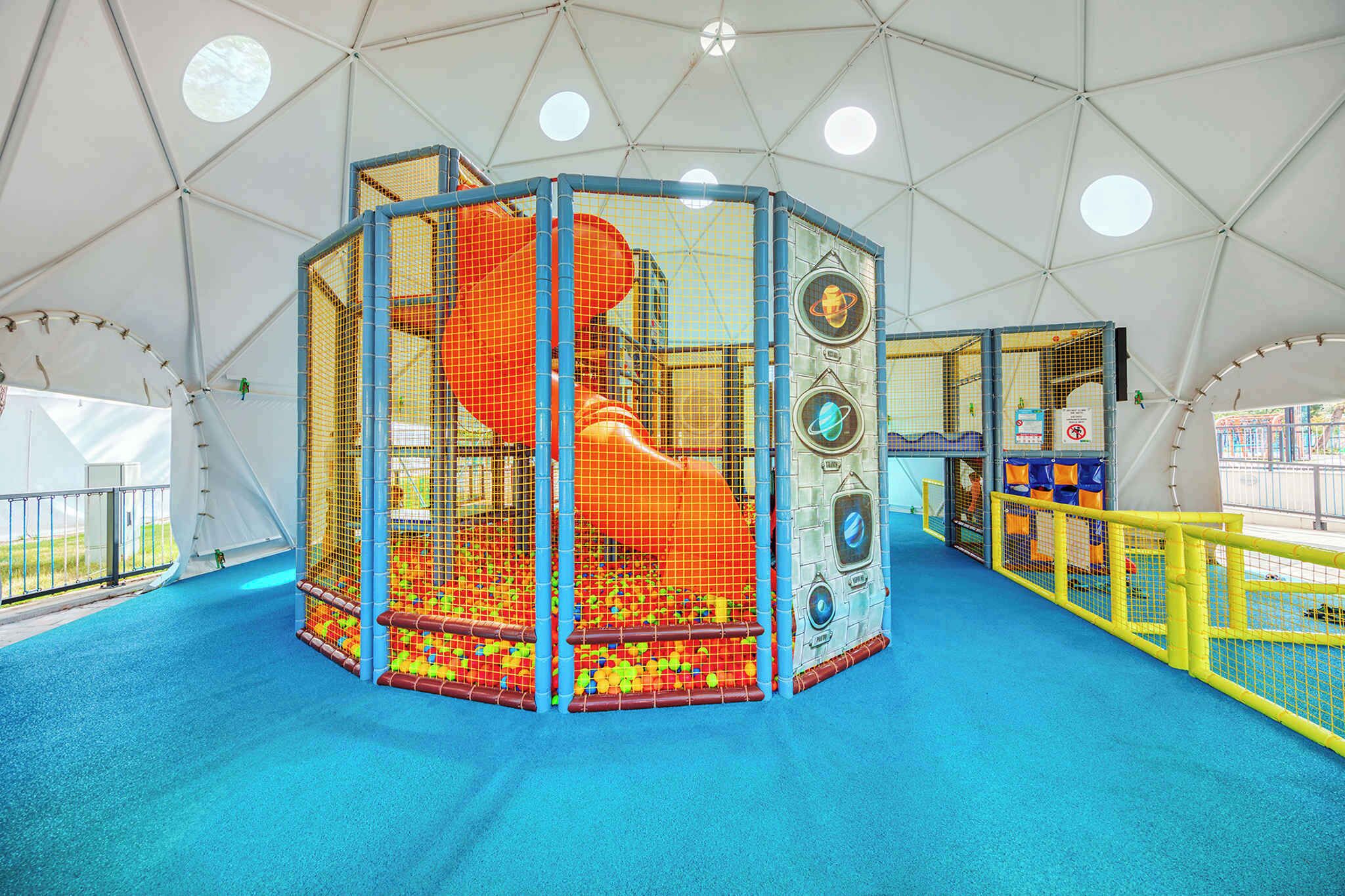 Un espace de jeux avec une structure d’escalade et une piscine à balles.