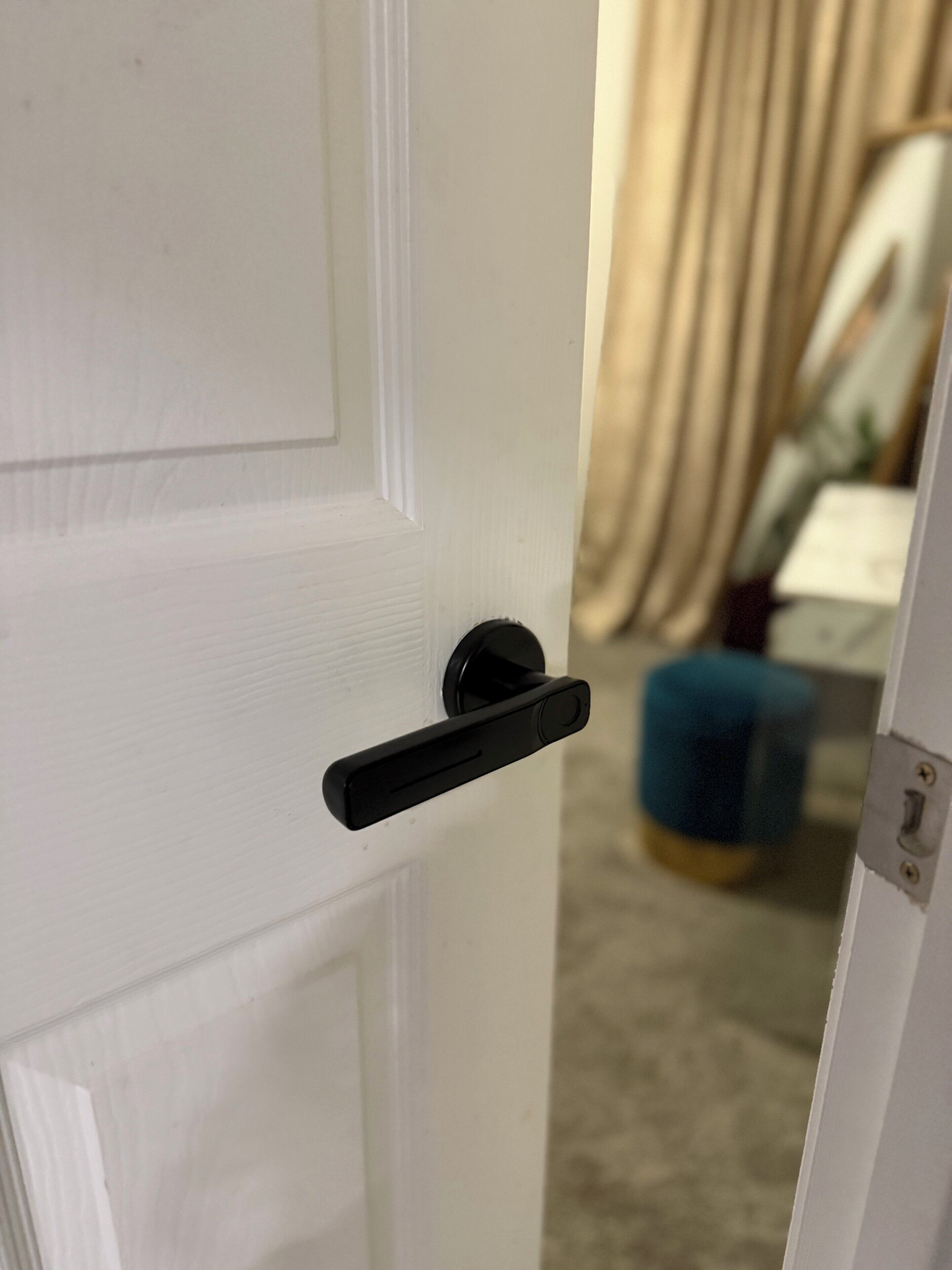 A white door with a black handle and a keyhole.