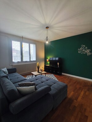 A living room with a sectional sofa, a coffee table, a TV stand, and a radiator. - House for 6 People Near Beauval (Selles-sur-Cher)