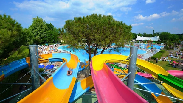 Un parco acquatico con scivoli colorati e una zona piscina.