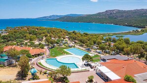 Un complexe hôtelier doté d’une grande piscine, de plusieurs villas et offrant une vue sur la mer et les montagnes.