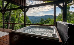 A hot tub on a wooden deck with a view of mountains and trees. - Timber Ridge-2 Bedroom, Pet Friendly, Luxury Cabin Rental, Panoramic Mountain Views, High Speed Internet, Rafting, Horseback Riding-Nantahala NC (Topton)