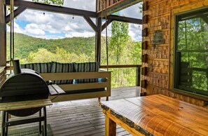 A wooden deck with a grill, a bench, and a table. - Timber Ridge-2 Bedroom, Pet Friendly, Luxury Cabin Rental, Panoramic Mountain Views, High Speed Internet, Rafting, Horseback Riding-Nantahala NC (Topton)